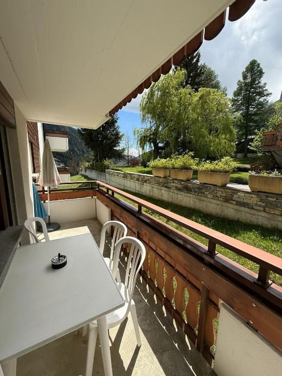 a table and chairs on a balcony with a view at Gonenstein 11 in Leukerbad