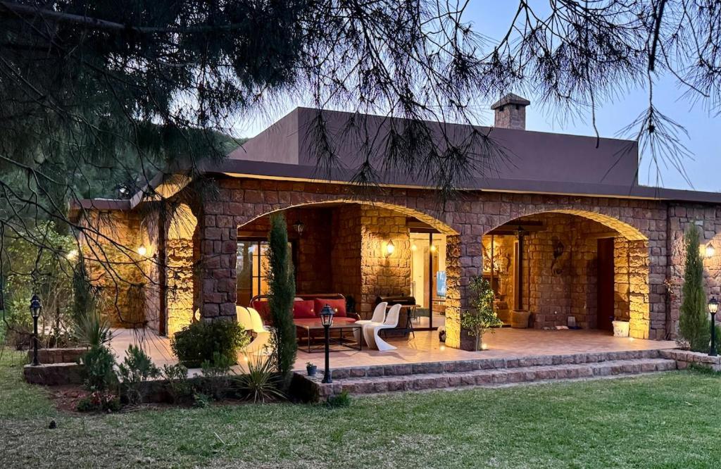 a brick house with a patio in the yard at Le Forestier in Dar el Hajri