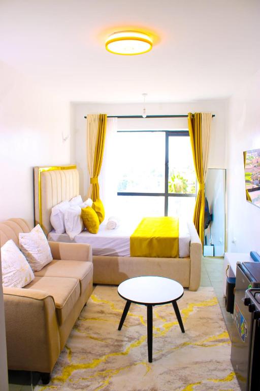 a living room with a couch and a bed at Victor Airport suites in Nairobi