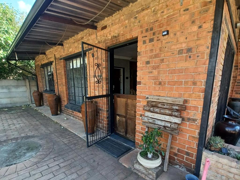 an entrance to a brick building with a black gate at Duncan Garden Cottage in Brakpan