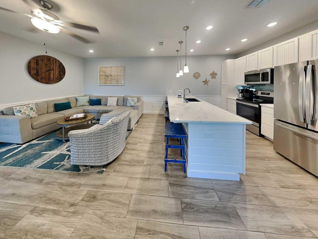 a kitchen and living room with a couch and a table at Port As Flip Flops & Pop Tops in Port Aransas