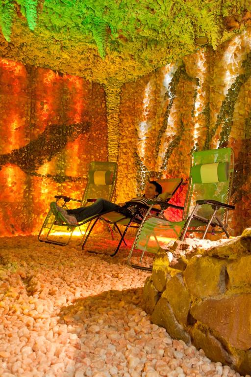 a woman sitting in chairs in front of a wall at Hotel Merkur - Jablonec nad Nisou in Jablonec nad Nisou