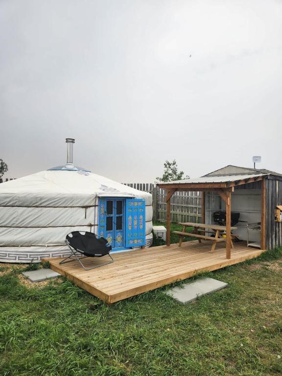 a yurt with a wooden deck and a grill at COTC - The Coulee Yurt - Suite in Castor