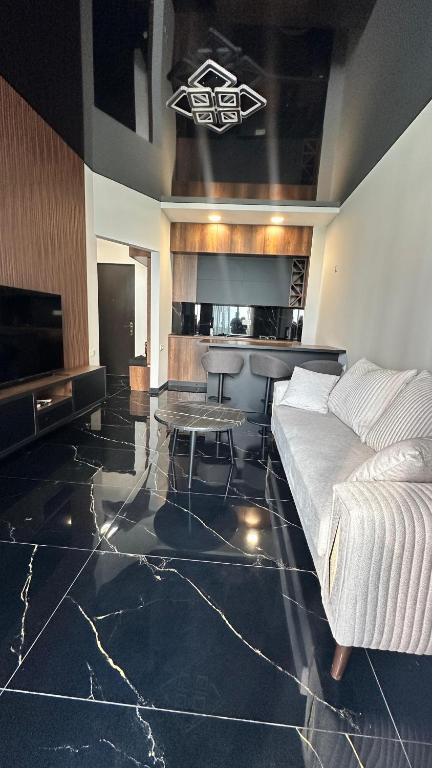 a bedroom with a bed and a table and a kitchen at Beach Apartment Chakvi in Chakvi