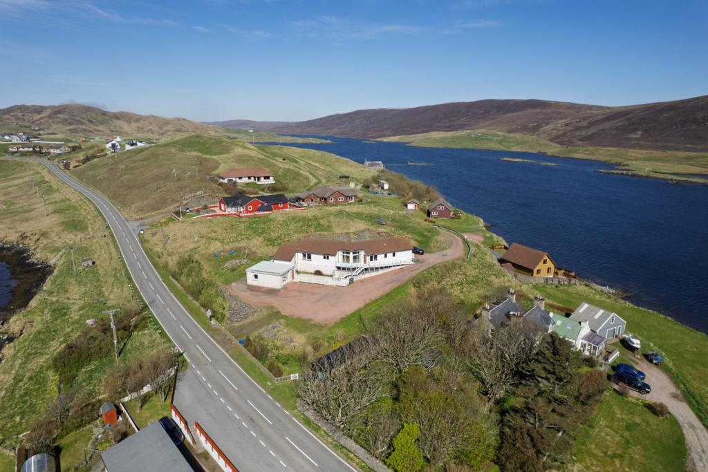 an aerial view of a house on a hill next to a road at Bellevue House, Shetland Islands in Whiteness