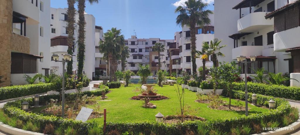 a garden in the middle of a building at Les dunes de martil familles in Martil