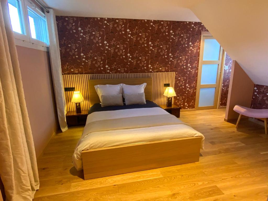 a bedroom with a large bed with two lamps at Le Cap Saint Jacques Chambre d hôtes proche de bayeux à 15 mn idéal plages du débarquement in Putot-en-Bessin