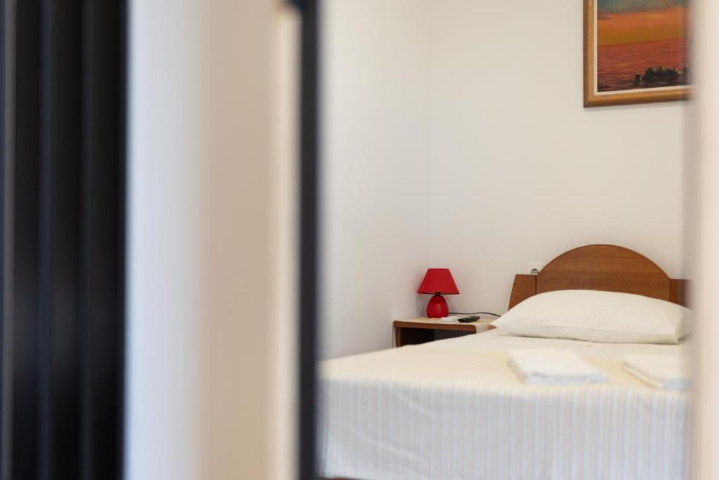 a bedroom with a bed and a table with a lamp at Apartman Lance in Kožino