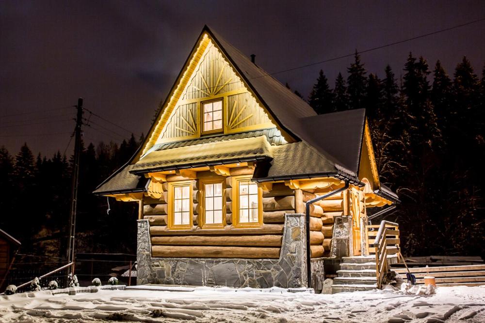 a log cabin in the snow at night at Domek Góralski Suche in Suche