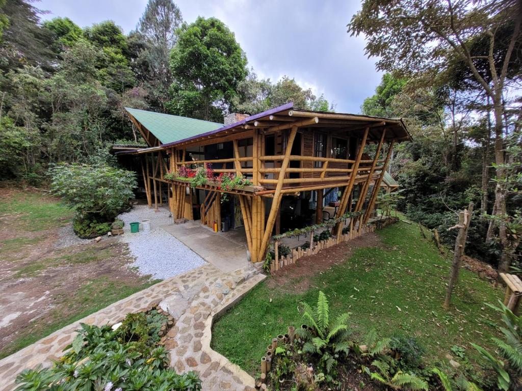 a large wooden house with a green roof at Refugio en el Bosque in Medellín