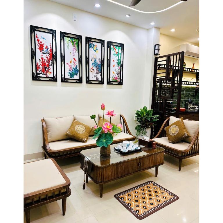 a living room with furniture and stained glass windows at HueS Home in Hue