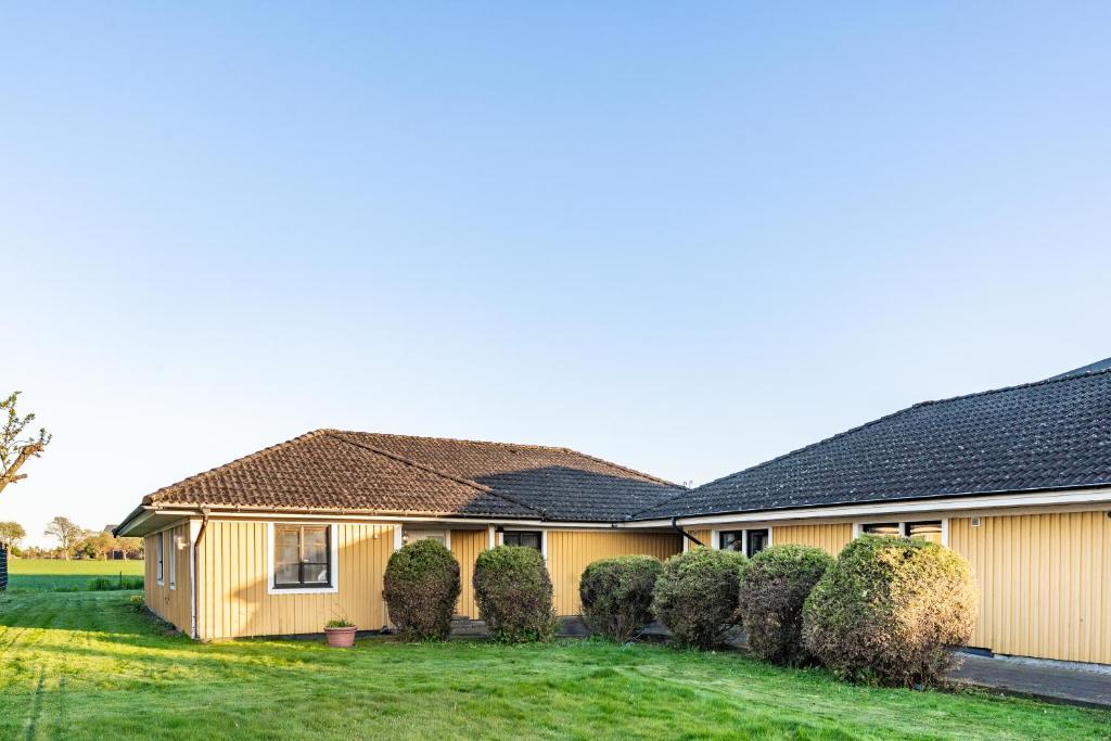 a house with bushes in front of it at Gula villan in Påarp