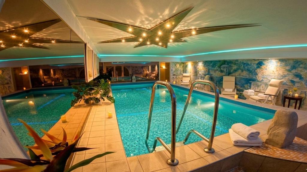a large swimming pool in a house with a ceiling at Hotel Im Schwedischen Hof in Binz