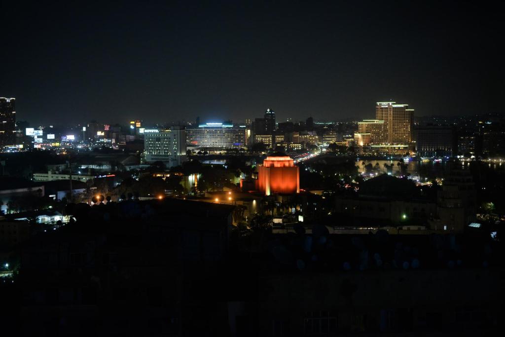 a view of a city at night with lights at Nile X Hostel - Nile view in Cairo