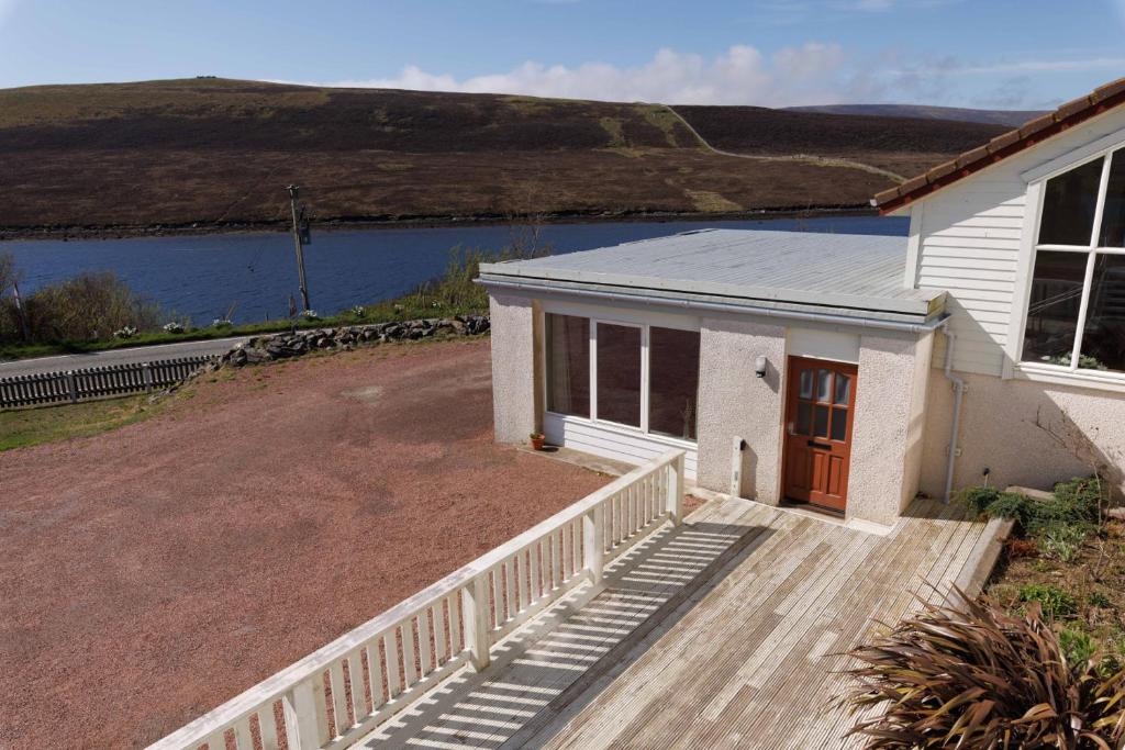 a small house with a porch and a driveway at Bellevue Apartment, Shetland Islands in Whiteness