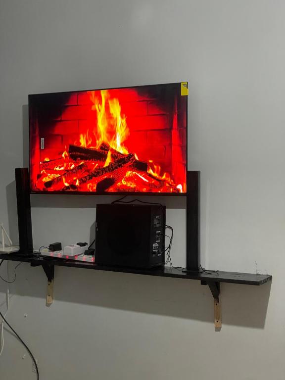 a fireplace on a shelf with a fire in it at Kilifi Studio in Kilifi