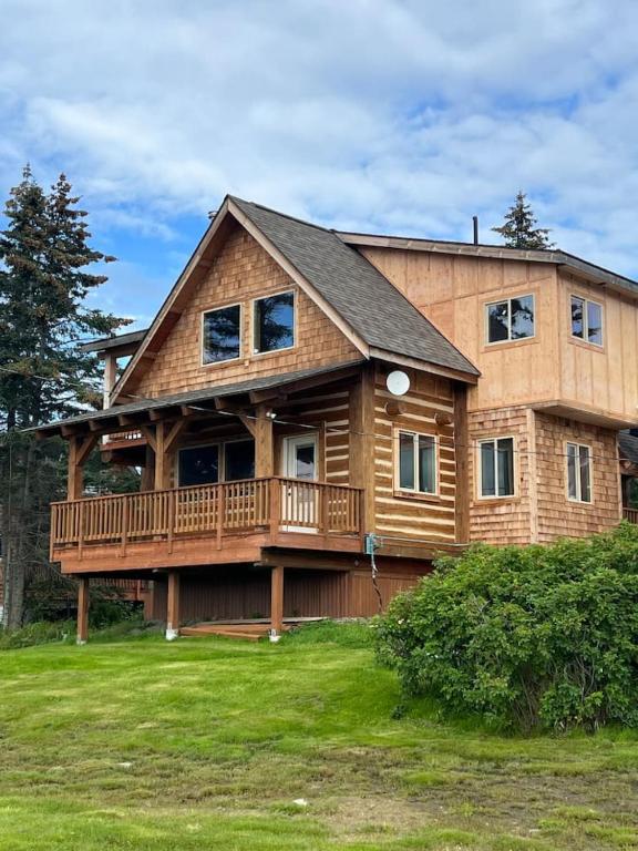 a large wooden house with a large deck at Homer Spit View Cabins - The Log Cabin in Homer