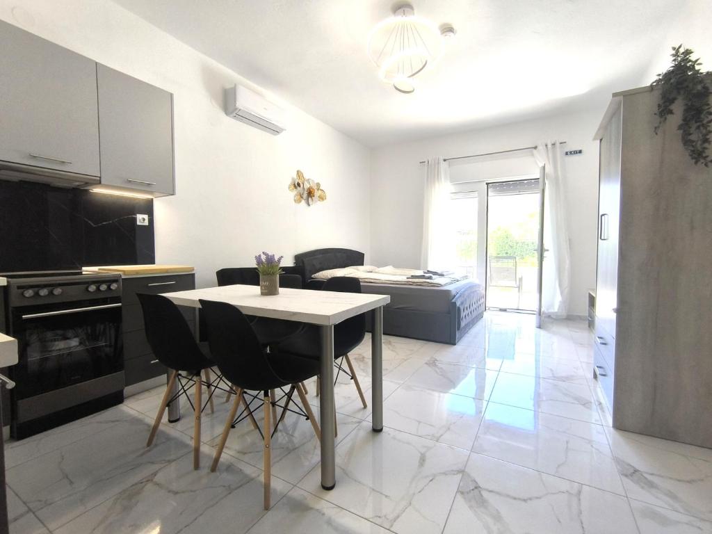 a kitchen with a table and chairs in a room at Rael Apartments - free Parking in Katerini