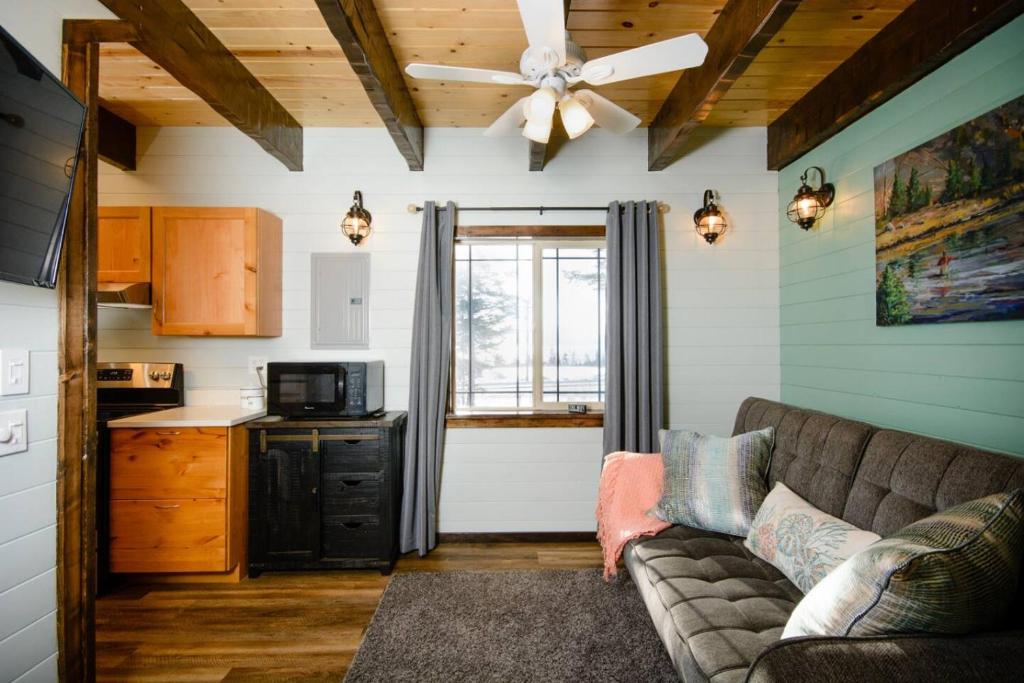 a living room with a couch and a kitchen at Homer Spit View Cabins - The Cottage in Homer