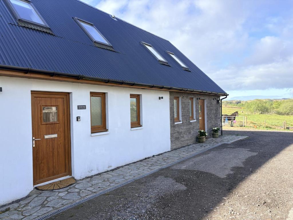 a house with a solar roof and a door at Abernethys Cottage in Connel