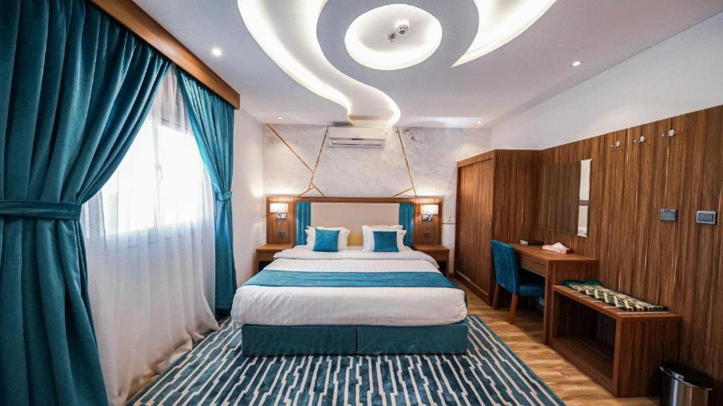 a bedroom with a bed and a large window at منازل الضيف in Jeddah