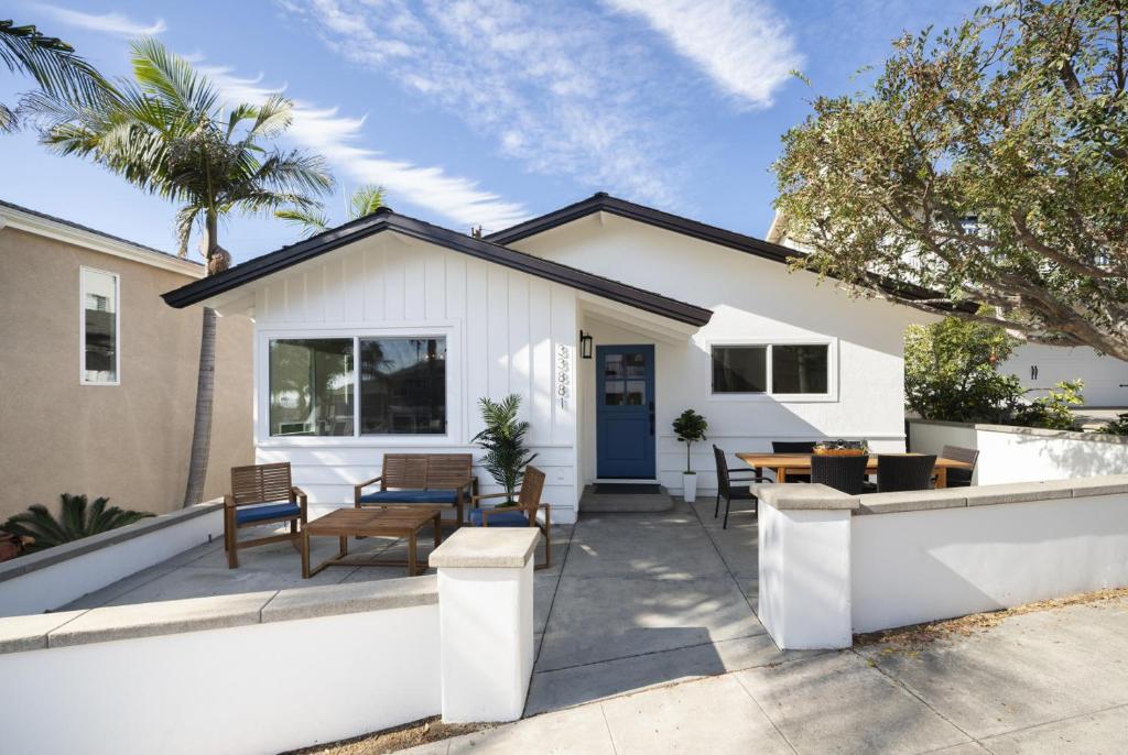 a patio with tables and chairs in front of a house at Dana Point Lantern District Retreat Beach Close in Dana Point