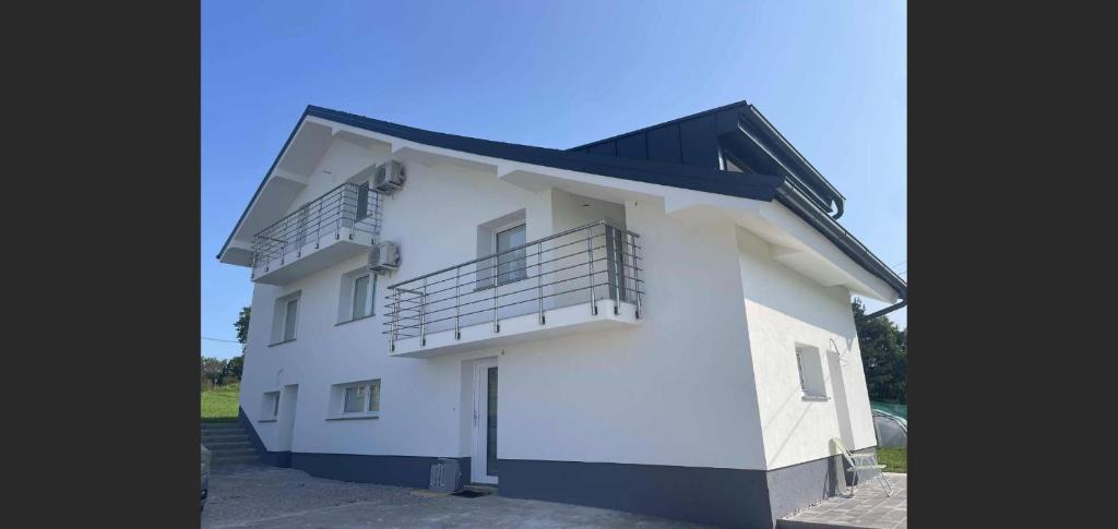 a white building with a balcony on top of it at Janez house in Metlika