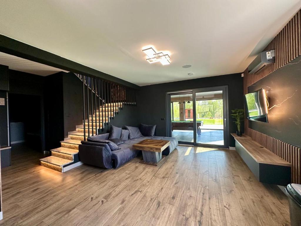 a living room with a couch and a staircase at Podlaski Chill in Przejma Wielka