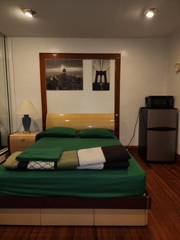 a bedroom with a large bed with green sheets at Sensational in Elizabeth