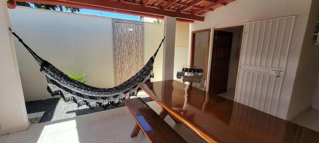 a dining room with a hammock in a room at Casa de praia em Guriri in Guriri