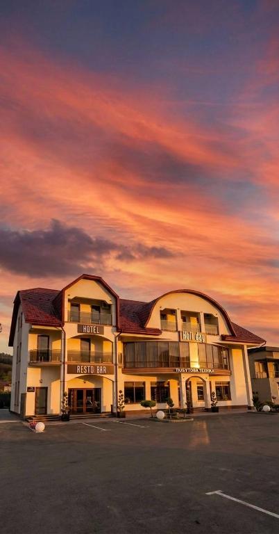 a hotel building with a sunset in the background at Holi Day in Solotvyno