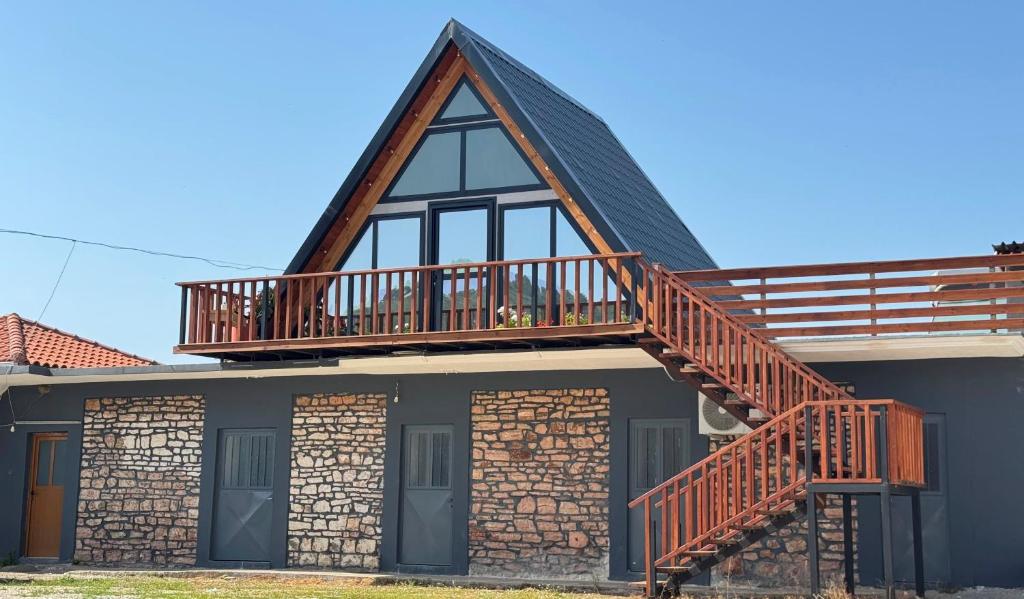 a house with a wooden deck on top of it at Konispol Mandarin Cabin in Mursi