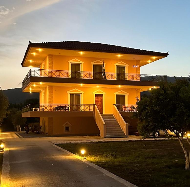 a large yellow house with a staircase in front of it at Elia in Marathon