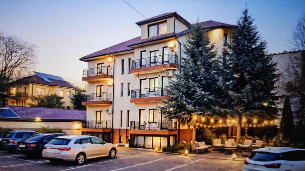 a large building with cars parked in a parking lot at Adori Boutique in Eforie Nord