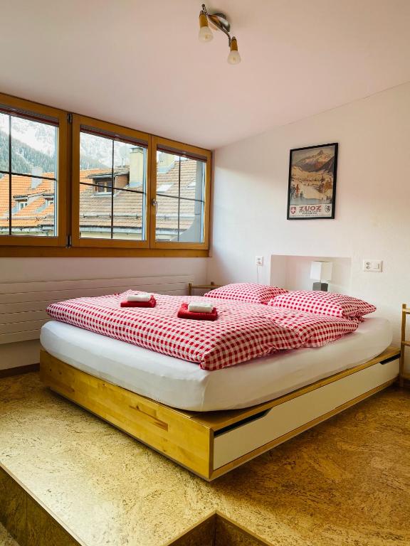 a bedroom with a large bed in a room with windows at Chesa Margadant in Zuoz