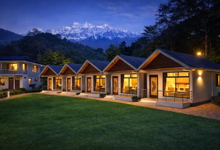 a large house with mountains in the background at Kanchankanya Hill Resort in Takdāh
