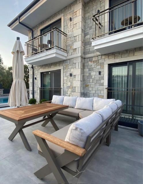 a patio with a couch and a table and a building at Bacbery Butik Otel in Çeşme