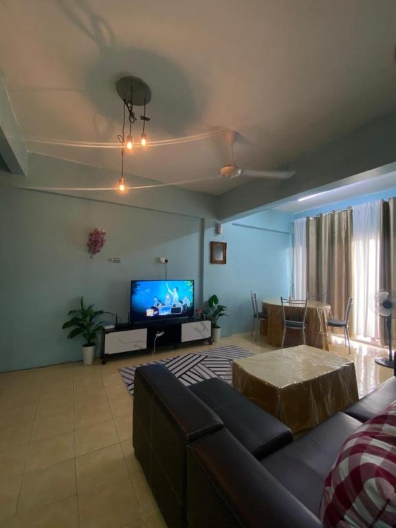 a living room with a couch and a flat screen tv at Homestay Plaza in Temerloh