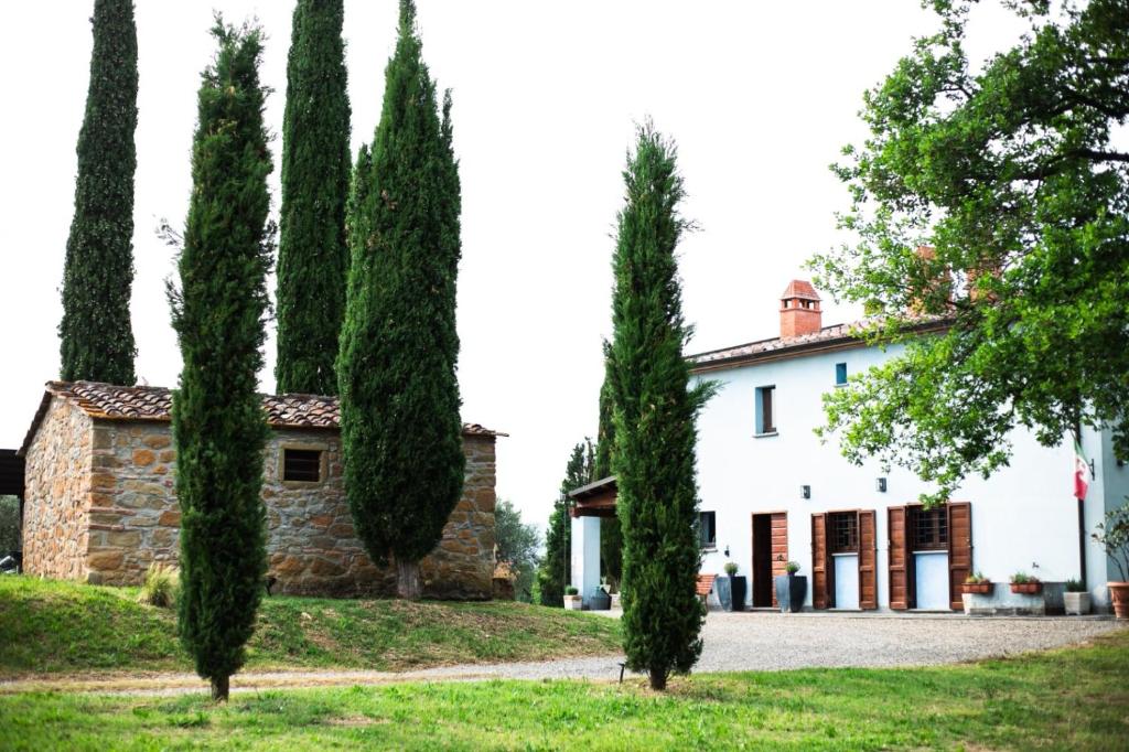 a house with cypress trees in front of it at Casina di Leonardo Arezzo in Arezzo