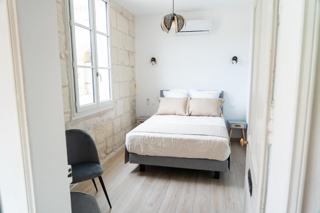 a small bedroom with a bed and a chair at Parnaydisiaque in Parnay