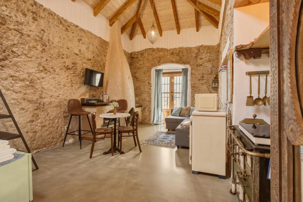 a kitchen and a living room with a table and a refrigerator at The Farm Lodge in Marbella