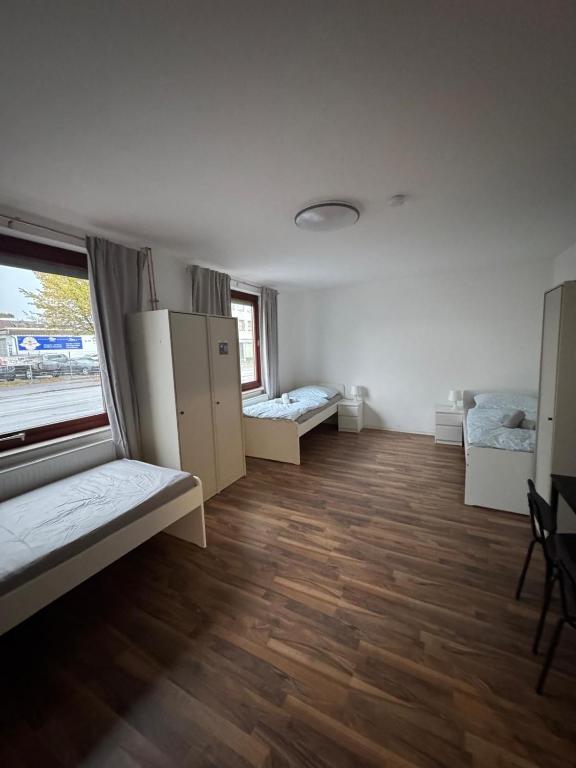 a large room with two beds and a window at Haven Lodge Komfortable Unterkunft für Monteure, Firmen und Gruppen in Bremerhaven in Bremerhaven