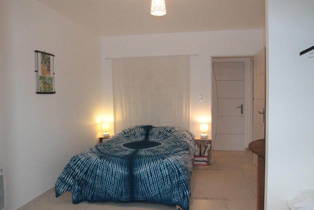 ein Schlafzimmer mit einem Bett und zwei Lampen an der Wand in der Unterkunft Entre Brousse Et Garrigue in Viols-le-Fort