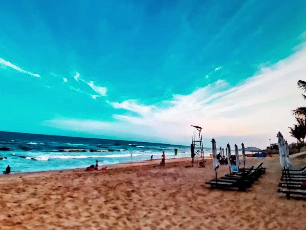 a beach with a group of people and the ocean at Aura Seaviews Suites in Phan Thiet