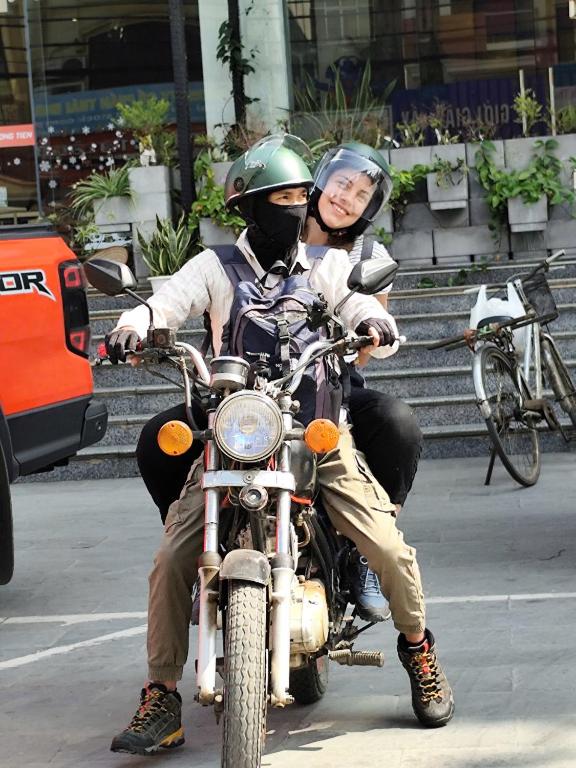 a man and woman riding a motorcycle on the street at Hava Hostel Lang Son in Lạng Sơn