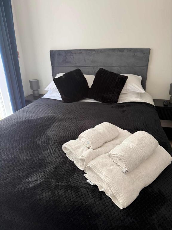 a bed with two white towels on it at Ground Floor Flat with Courtyard garden in Weston-super-Mare