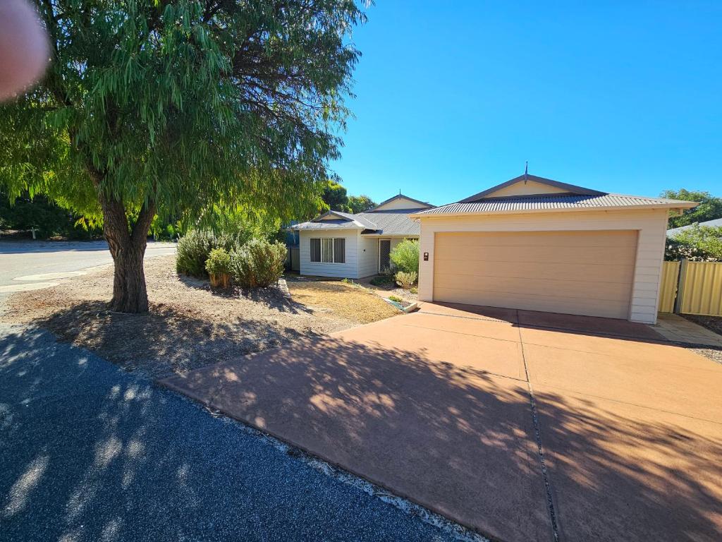a house with a tree in front of a driveway at Hopetoun - footprints in the sand in Hopetoun