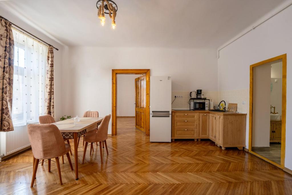 a kitchen and dining room with a table and a refrigerator at Gloria Apartments in Sighişoara