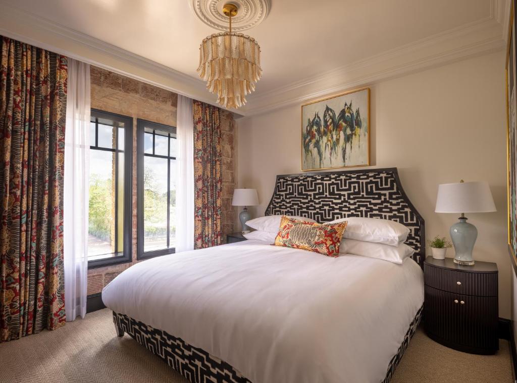 a bedroom with a large white bed and a window at The Faust Hotel in New Braunfels