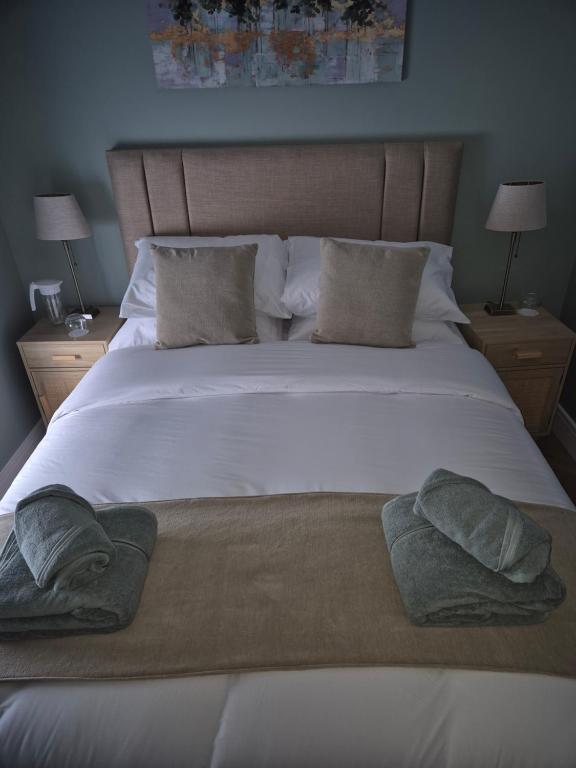 a large white bed with two pillows on it at The Ledger Rooms in Gort